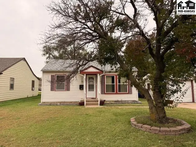 This white vinyl-sided house features a red-trimmed front door and windows.