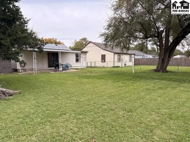 A fenced backyard surrounds this single-story home with a covered patio.