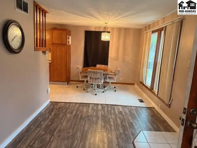 This dining area features a wood-tone table with four chairs on a tiled floor.