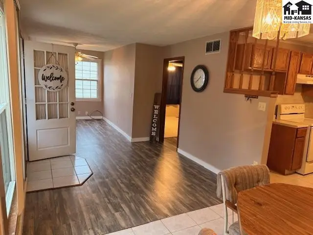 This interior features wood-look flooring, a neutral color palette, and a doorway leading to another room.